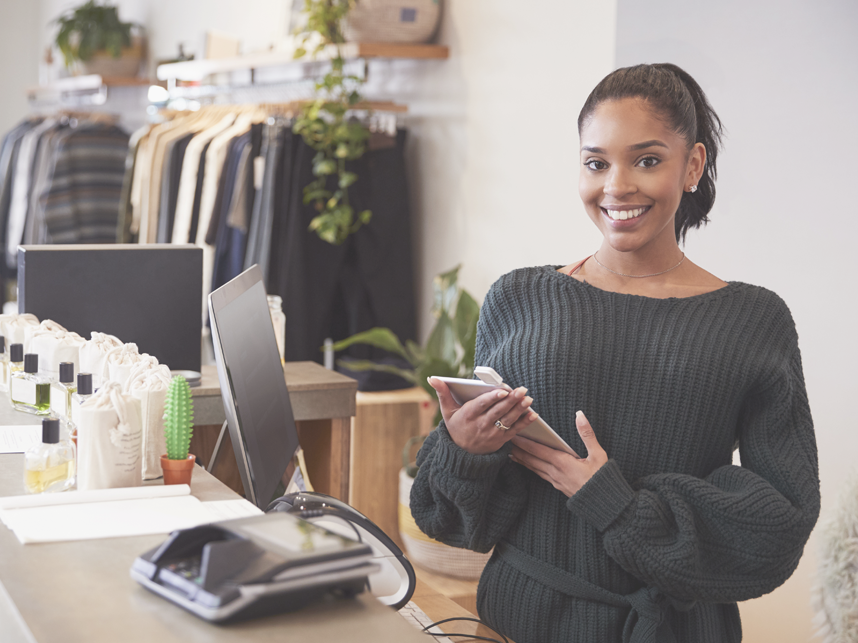 Female assistant smiling from the counter in clothing store