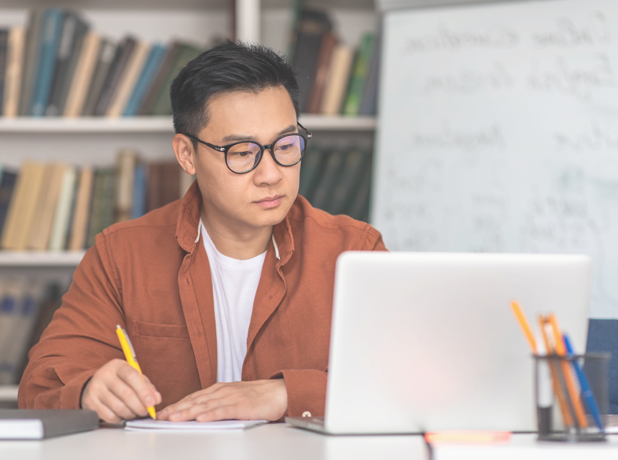 Korean middle-aged trainer using laptop and preparing for a training session.