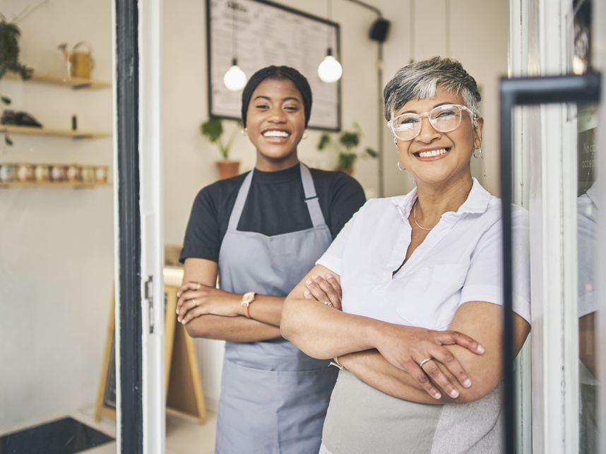 Coffee shop, senior woman manager portrait with barista feeling happy about shop success. Female server, waitress and small business owner together proud of cafe and bakery growth with a smile 