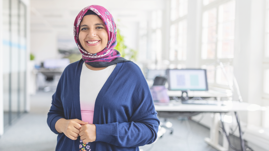 Portrait of happy mid adult Muslim woman standing at startup office