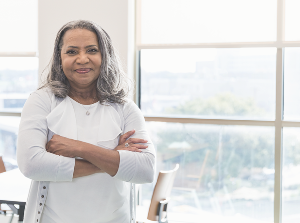 An image of a middle aged woman in a casual setting smiling and looking at the camera.