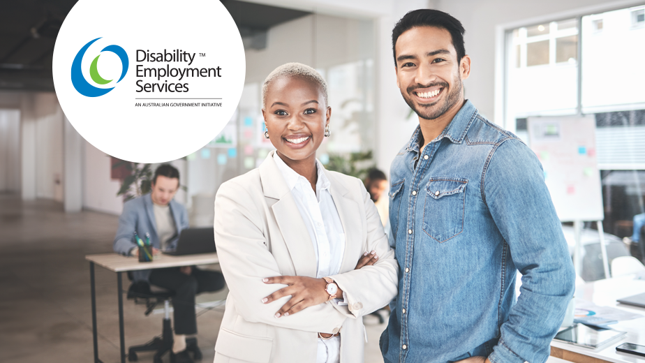 Portrait of two employees in a casual office setting looking at the camera and smiling.