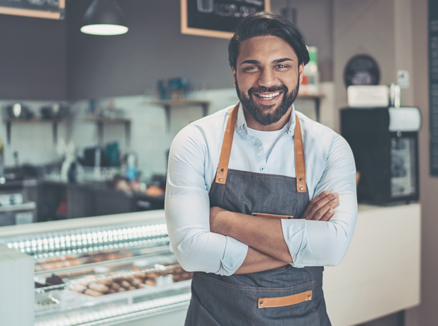 Cheerful Indian male small business owner looking to camera smiling confidently 