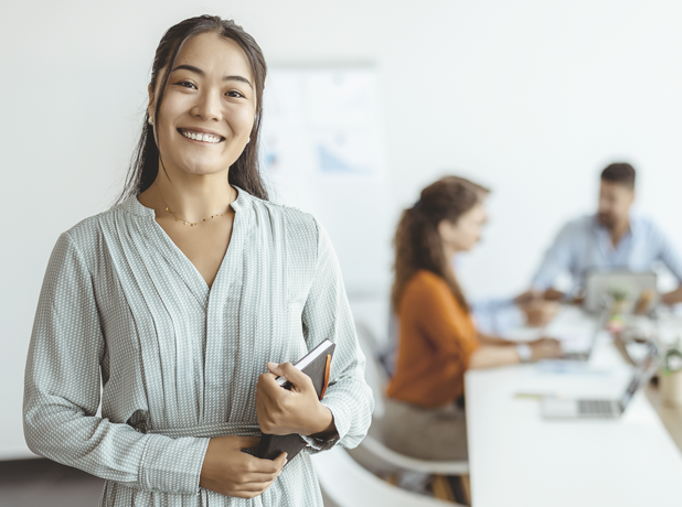 A woman smiling at the camera in an office.