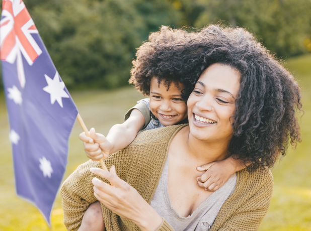 African mother and son waving Australian flag