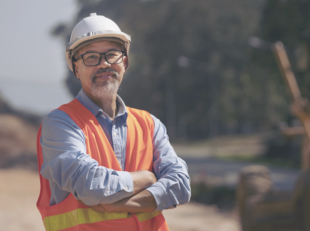 Asian man in hard hat smiling at camera