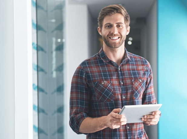 Anglo-saxon man standing with ipad smiling to camera